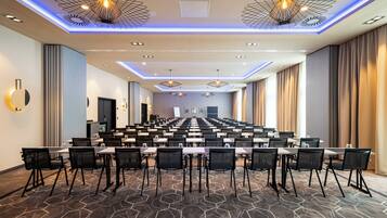 Ein Konferenzraum mit einem langen Tisch, Stühlen und einem gemusterten Teppich.