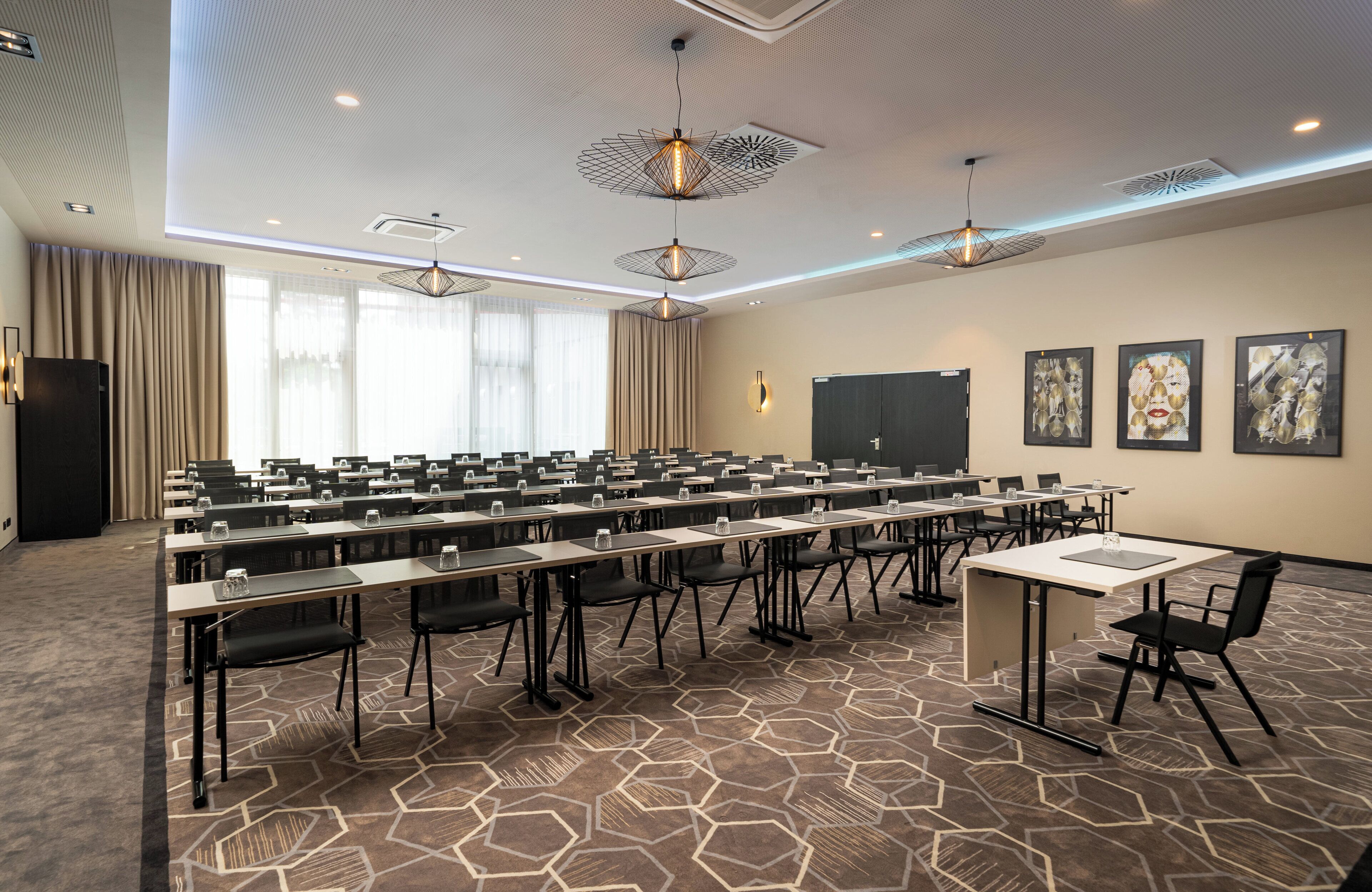 A conference room with multiple tables, chairs, and a projector screen.
