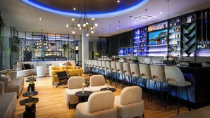 A modern bar area with seating and a bar counter. - Leonardo Royal Hotel Cologne Bonn Airport (Cologne)