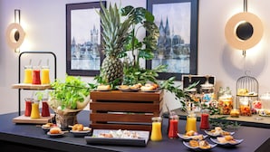 A buffet table with various food items, drinks, and a pineapple centerpiece. - Leonardo Royal Hotel Cologne Bonn Airport (Cologne)