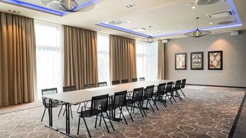 A conference room with a long table, chairs, and a patterned carpet.