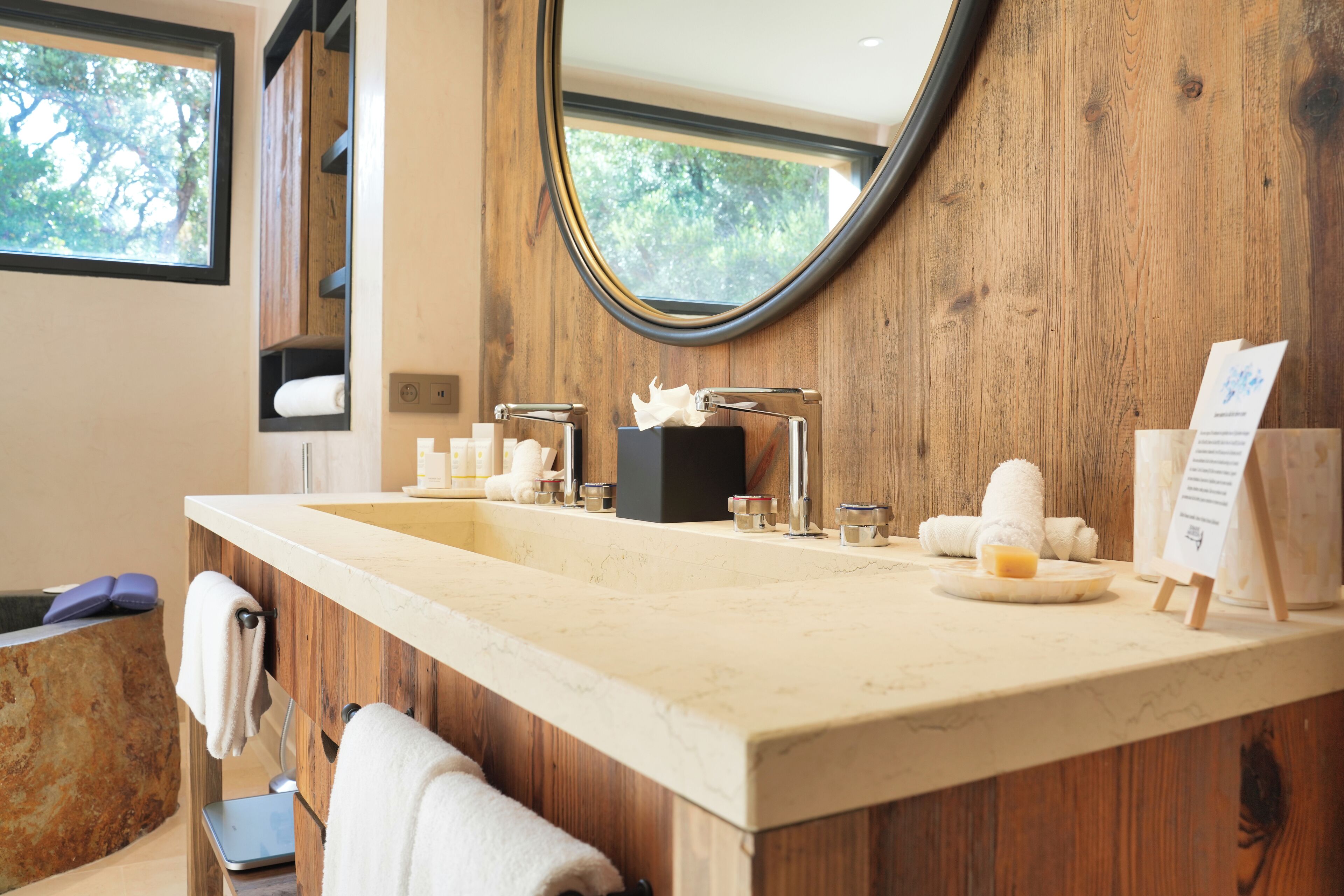 Une salle de bain avec un meuble-lavabo en bois, un grand miroir et un évier.