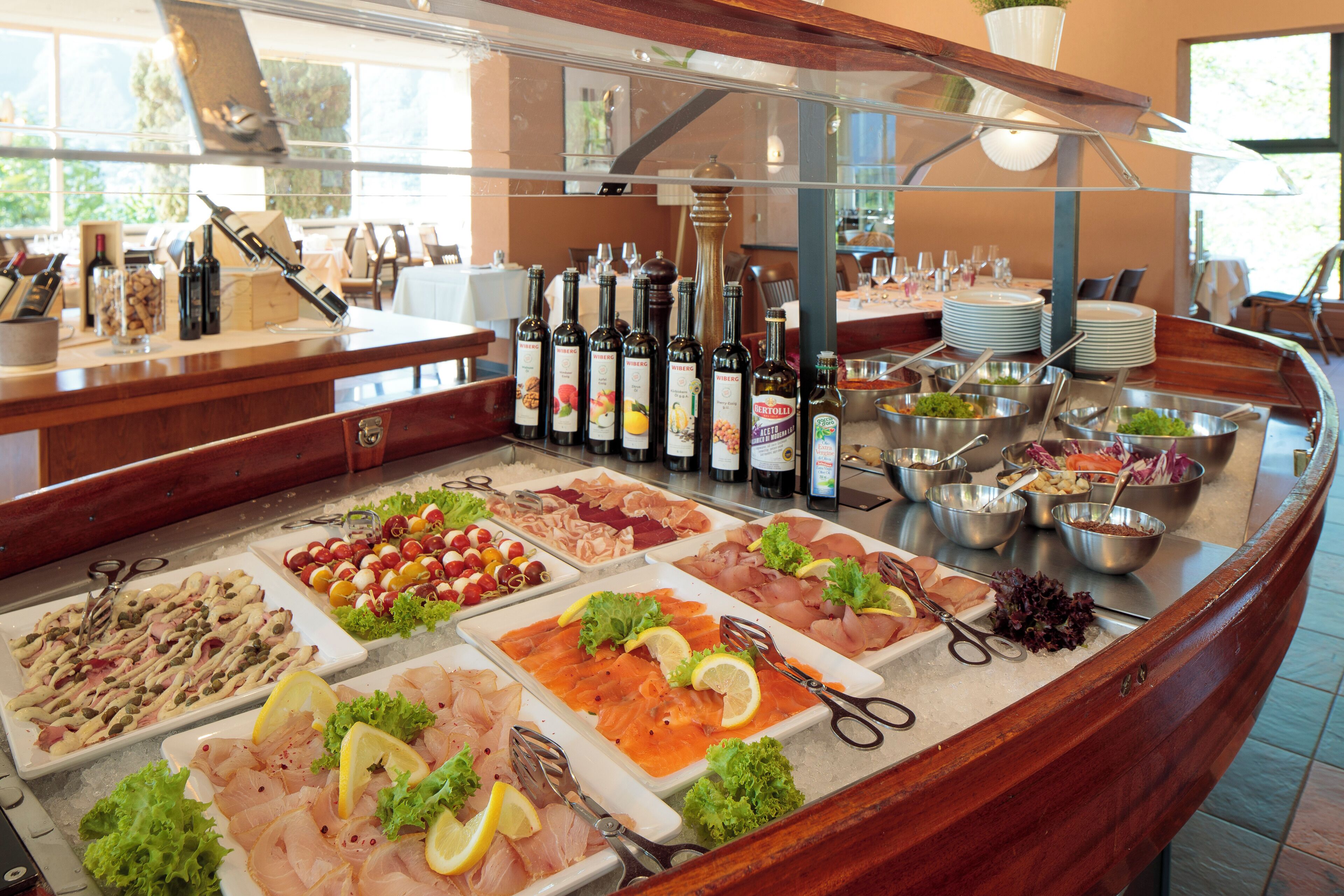 A buffet with various food items and a selection of wines.