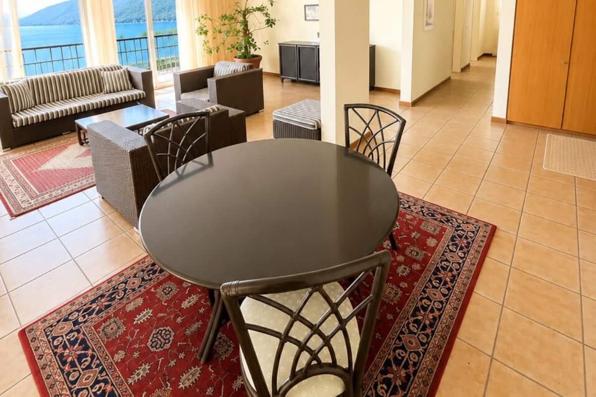 Una habitación con una mesa de comedor, sillas, un sofá y vistas al mar.