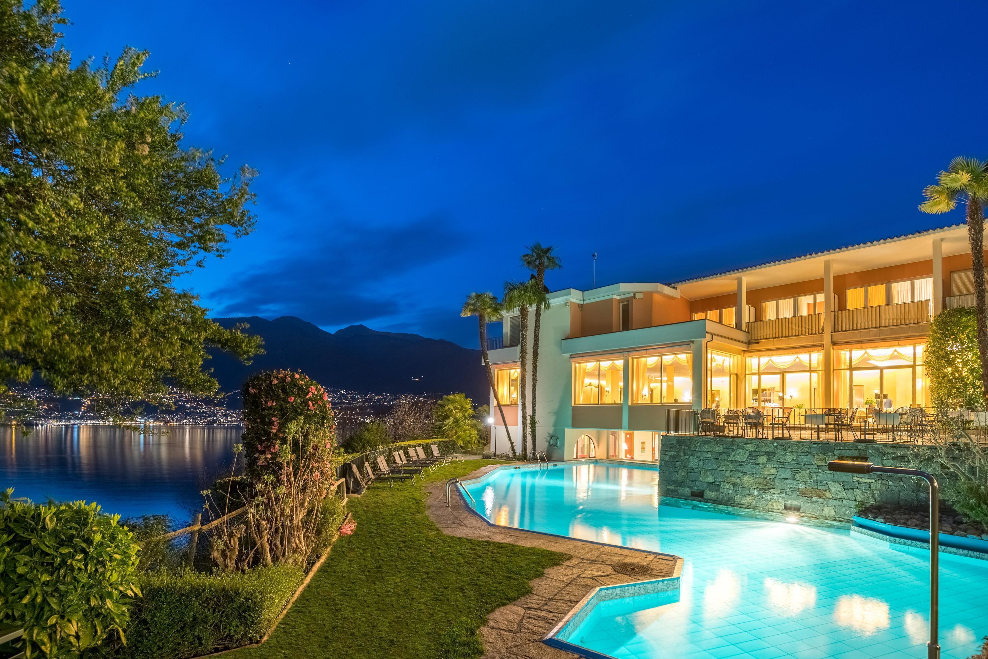 Ein modernes Hotel mit Pool, Außenbereich und Blick auf Stadt und Berge.