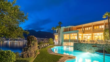 Ein modernes Hotel mit Pool, Außenbereich und Blick auf Stadt und Berge.