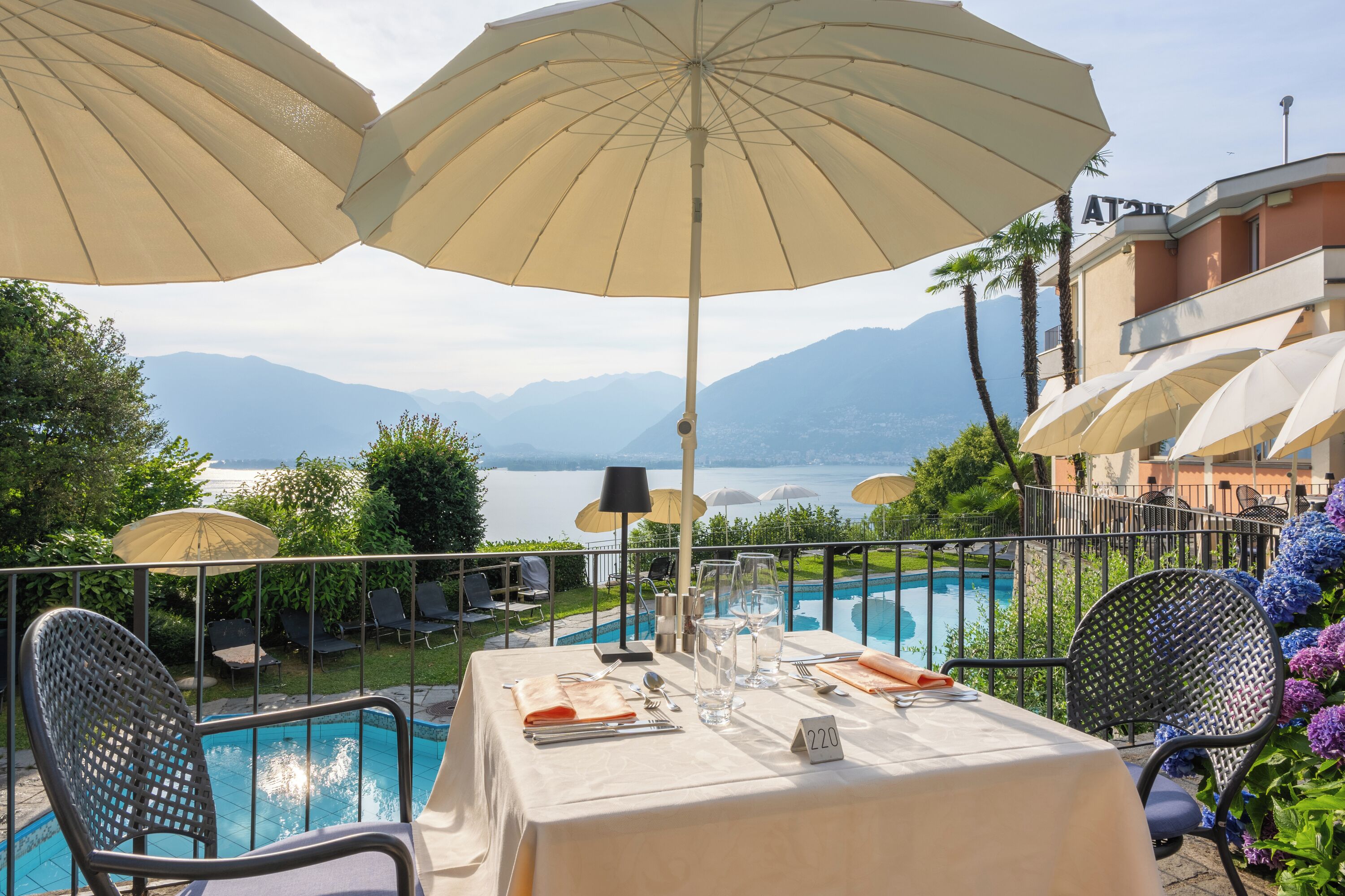 Ein Esstisch mit Blick auf einen Pool und Berge im Hintergrund.