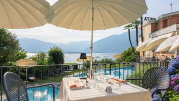 A table set for dining with a view of a pool and mountains in the background.