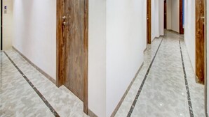 Un pasillo con puertas de madera y suelo de mármol.