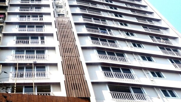 Un edificio de hotel de varios pisos con balcones y un letrero que dice Hotel Nirvana Grace.