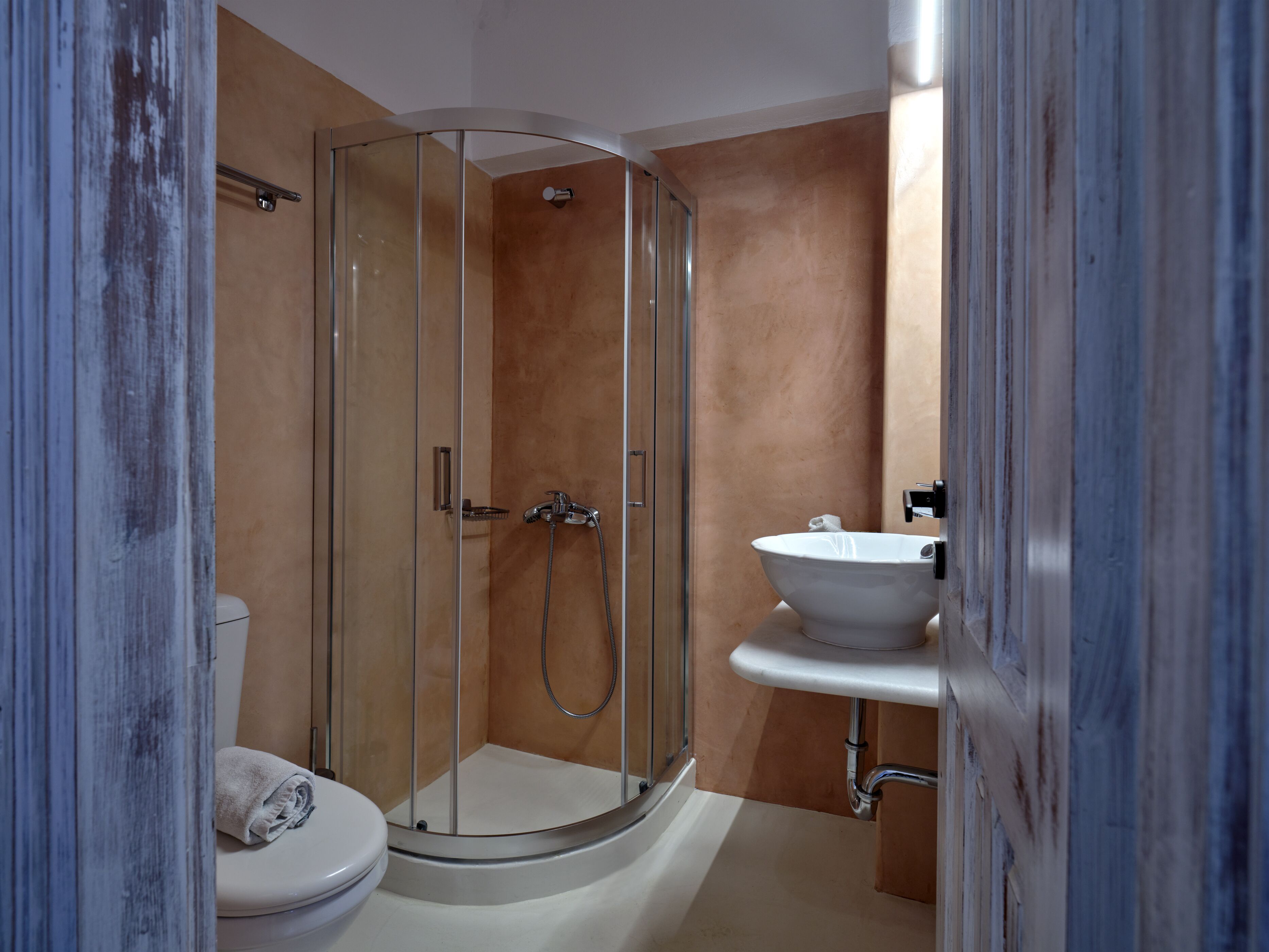 A modern bathroom with a glass-enclosed shower, a white toilet, and a white sink.
