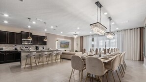 A modern kitchen with dark cabinets, a central island, and bar stools.