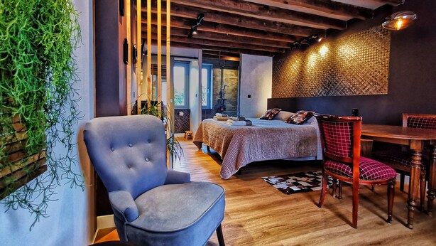 A modern bedroom with a bed, a chair, and a dining table. - La Jacquière - Chambres de charme (Chaumont-sur-Loire)