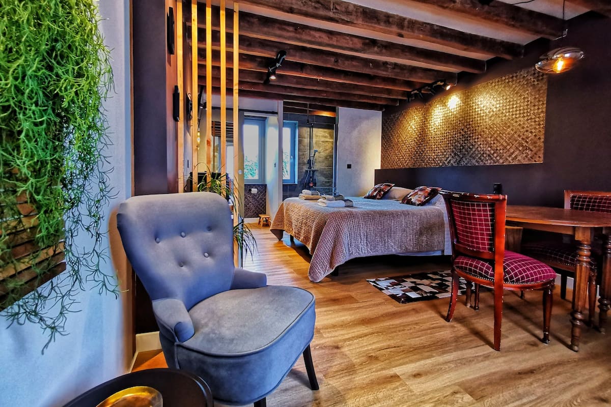 Un dormitorio moderno con cama, una silla y una mesa de comedor.