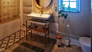 A bathroom with a bathtub, a sink with a mirror, a toilet, and a window. - La Jacquière - Chambres de charme (Chaumont-sur-Loire)