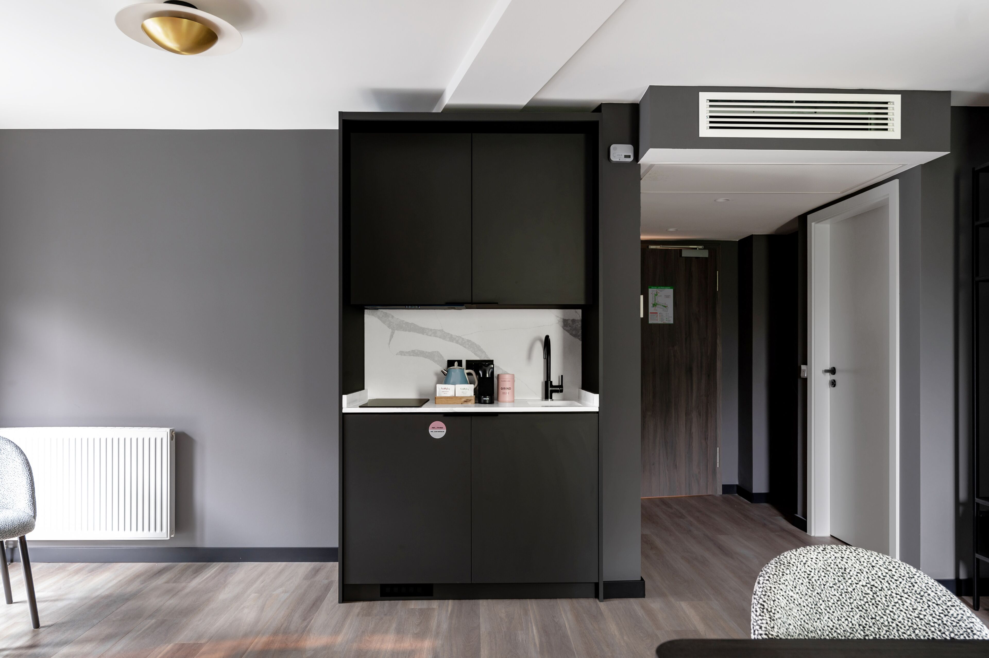 Una cocina moderna con microondas integrado, cafetera y hervidor en la encimera.