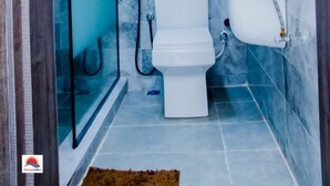 A modern bathroom with a glass shower enclosure, a toilet, and a sink. - Horizon Suites (Ibadan)