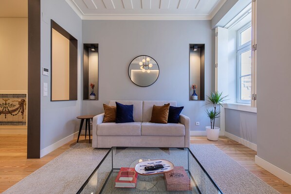 Una sala de estar moderna con un sofá, una mesa de centro y un espejo grande.