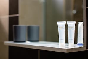 Un estante de baño con tres productos para el cuidado del cabello y el cuerpo y un logotipo de SavinDude.
