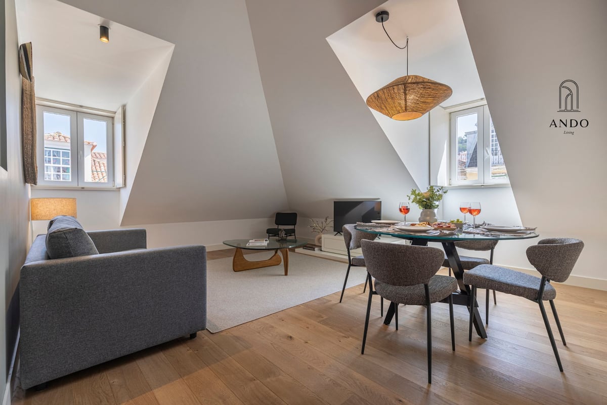Un appartement moderne de style « loft », comprenant un coin repas, un canapé et un téléviseur.