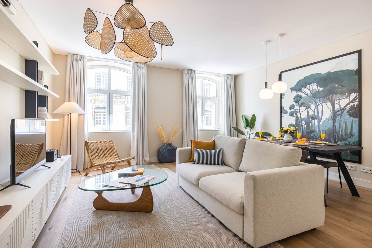 Un salon moderne avec un canapé, une table basse et un tableau accroché au mur.