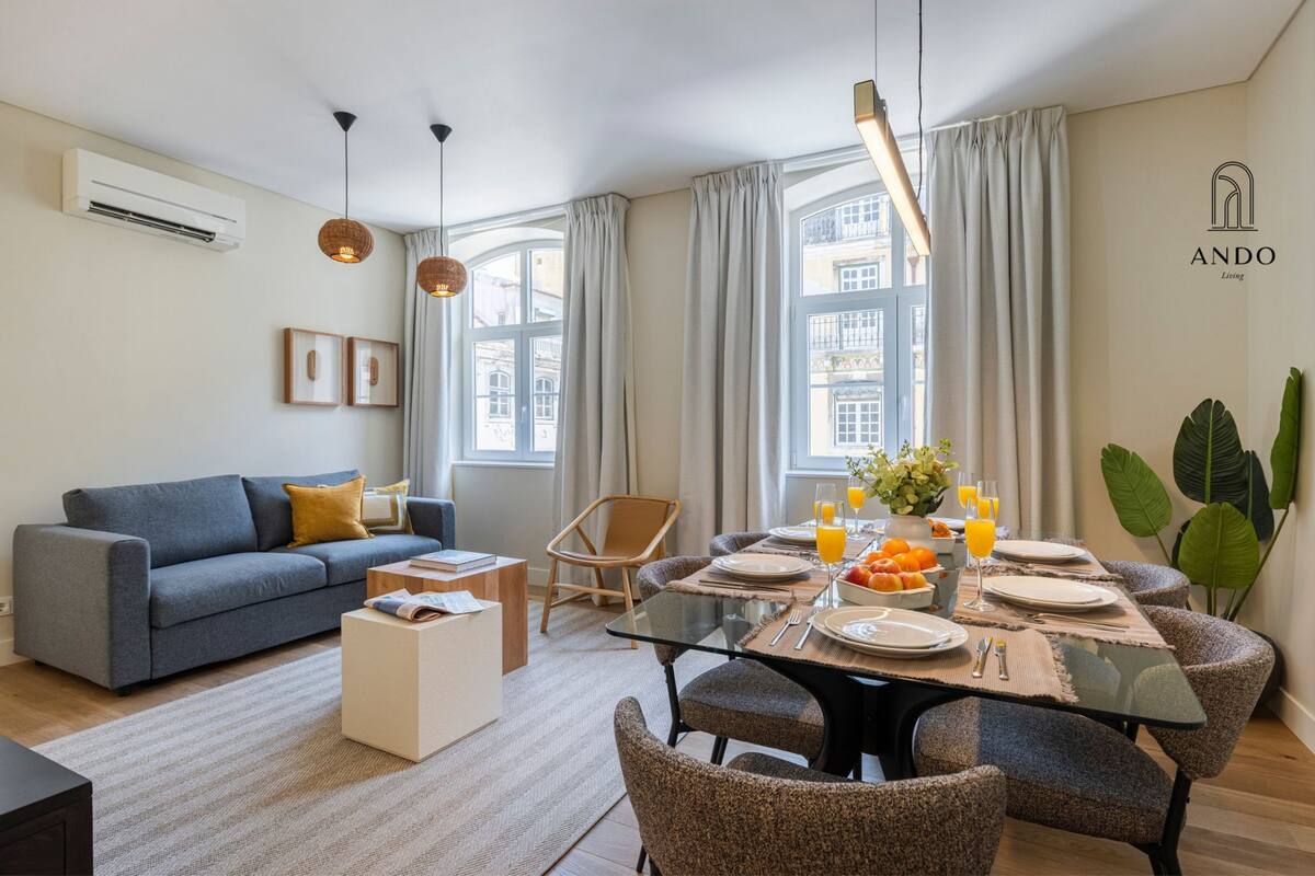 Un salon moderne comprenant un canapé, une table à manger, des chaises et une table basse.