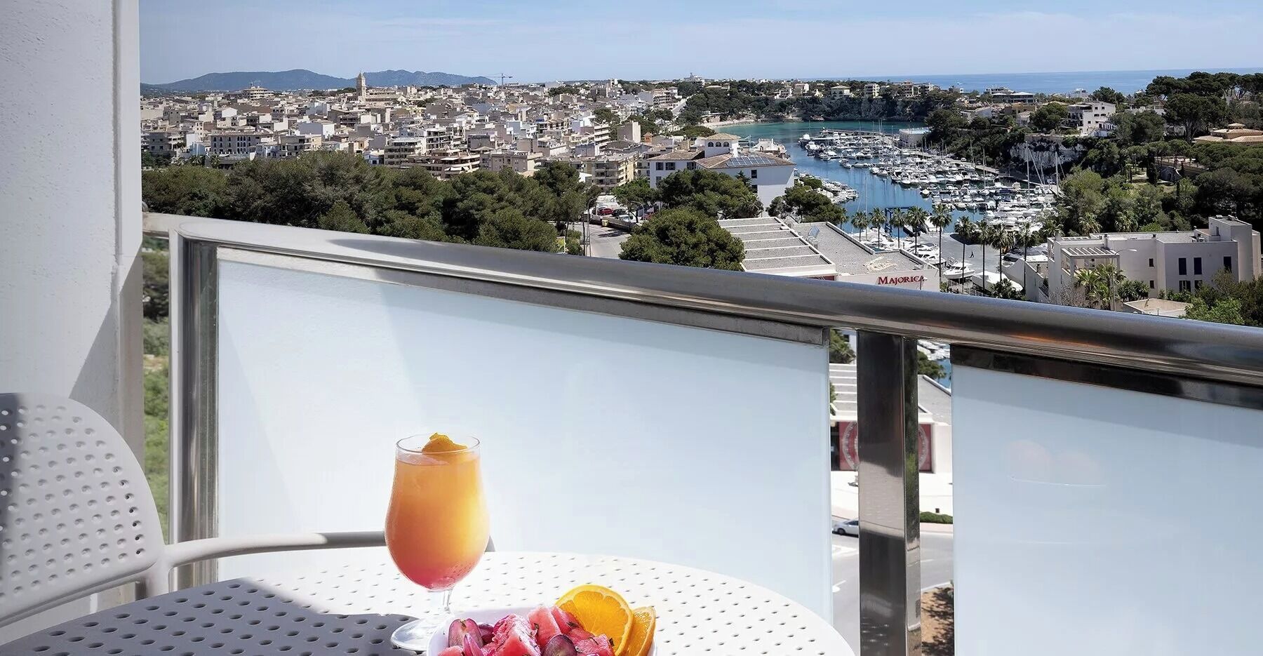 A balcony with a view of a marina and cityscape.