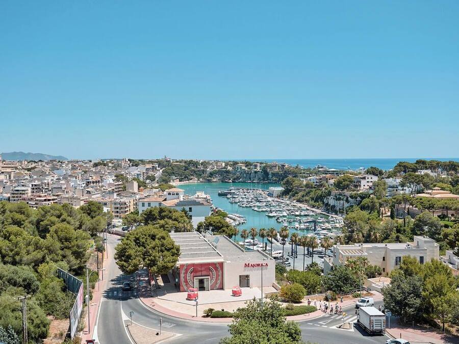A coastal cityscape with a marina, buildings, and a prominent 'MAJORCA' sign.