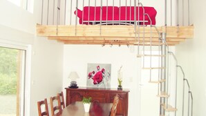A room with a bunk bed, a dining table, chairs, a lamp, and a painting. - House with heated swimming pool 3 km from the beach (PLEUMEUR BODOU)