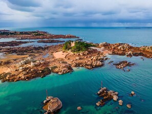 Un paysage côtier caractérisé par un terrain rocheux et des eaux d’un bleu limpide.