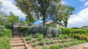 A stone staircase leading up to a house surrounded by lush greenery and a stone wall. - Lunaria + Solaria + Nuvola by Interhome (Ambra)
