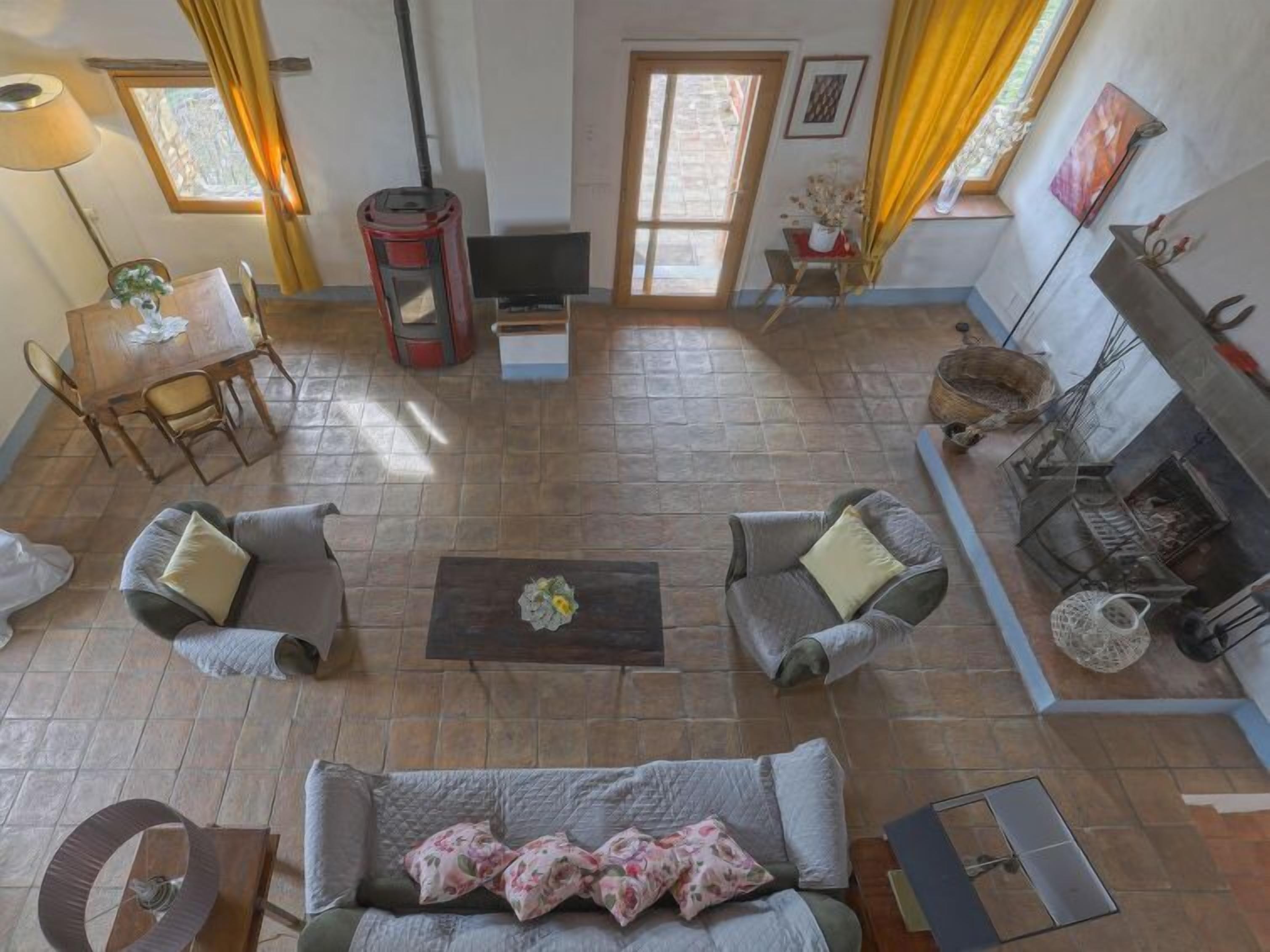 A spacious living room with a fireplace, a dining area, and a kitchen visible through an open door.