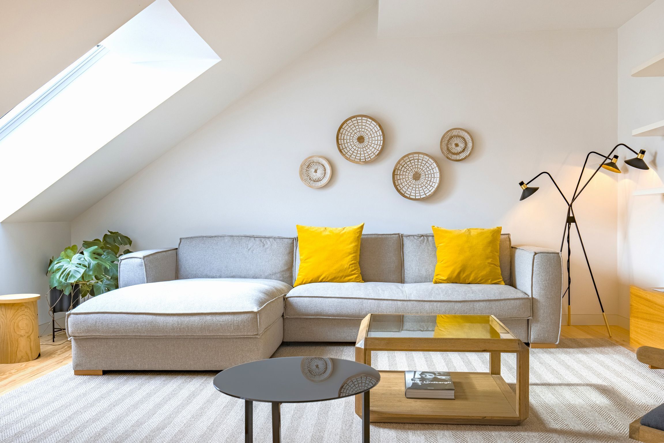 A modern living room with a sectional sofa, a coffee table, and a floor lamp.