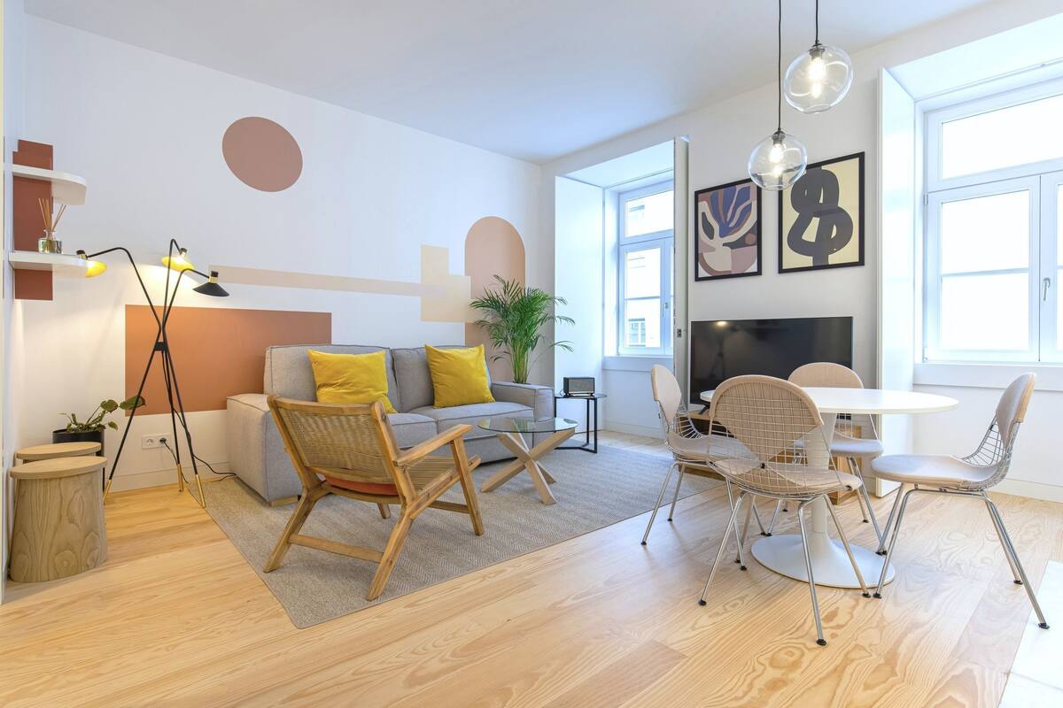 A modern living room with a sofa, chairs, a coffee table, and a fireplace.