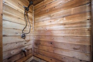 A wooden cabin with a shower area. - Mid-Way on 3rd, Sleeps 10, Sauna and Firepit with tow living rooms and fenced back yard (Kalispell)