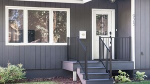 Ein Haus mit Veranda, einer Treppe zum Eingang und einem Briefkasten.