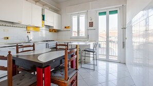 Una cocina moderna con armarios blancos, una mesa de comedor con sillas y un ventanal con vistas.