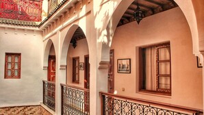 A corridor with arches, a tiled floor, and a balcony with ornate railings. - Saffron Room, Riad Arabic House & Spa (Marrakesh)
