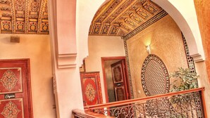A grand hallway with ornate red doors, a decorative ceiling, and a wrought iron railing. - Saffron Room, Riad Arabic House & Spa (Marrakesh)