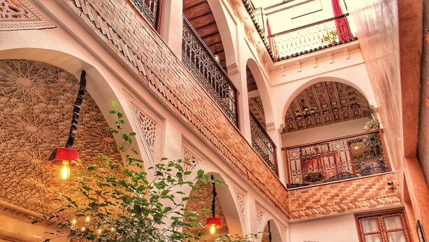 A multi-level interior with ornate arches, hanging lights, and potted plants. - Saffron Room, Riad Arabic House & Spa (Marrakesh)