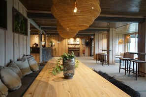 A spacious room with a long wooden table, a woven light fixture, and a plant centerpiece. - Lillehammer Turistsenter Budget Hotel (Lillehammer)