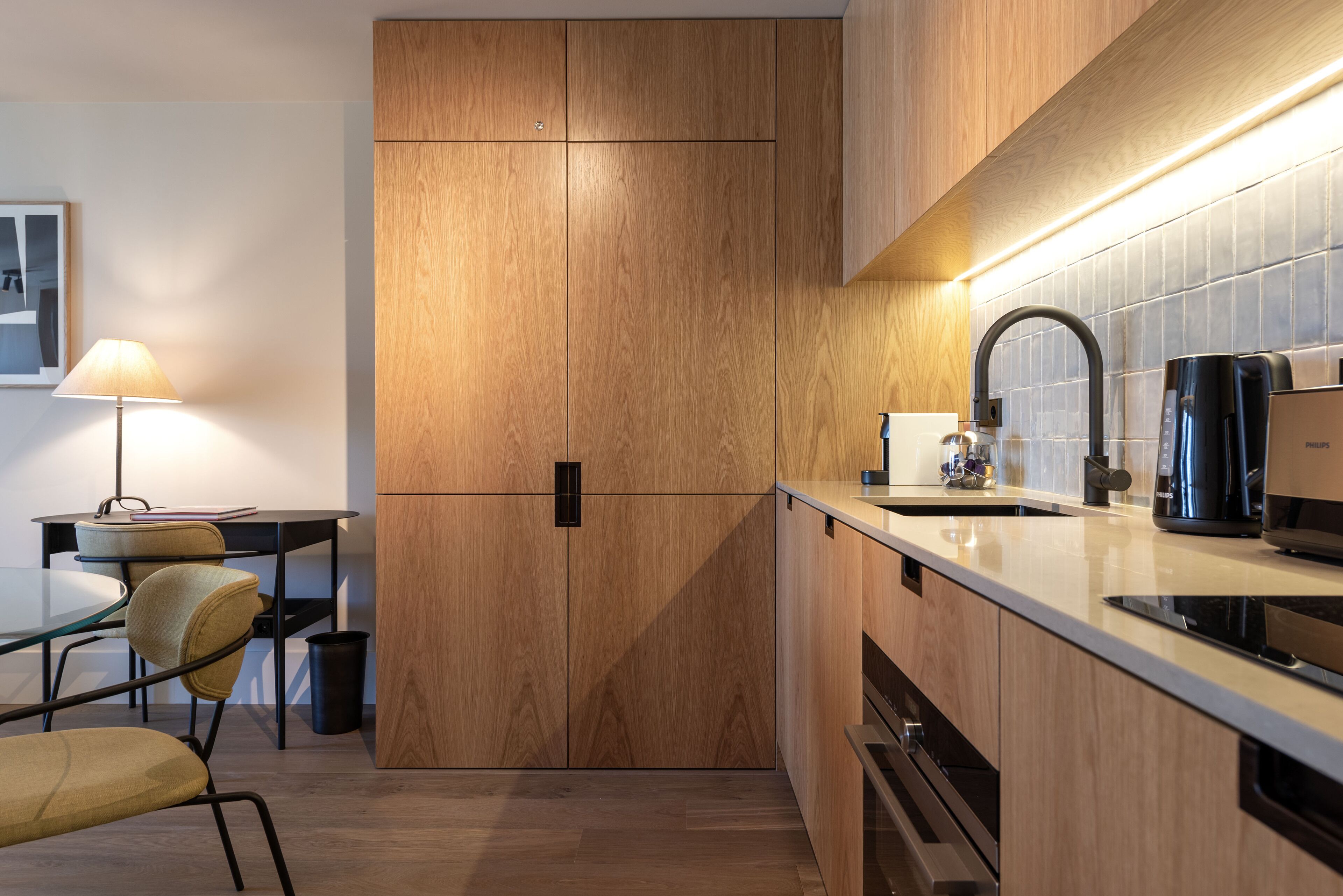 A modern kitchen with wooden cabinets, a black faucet, and a coffee maker.