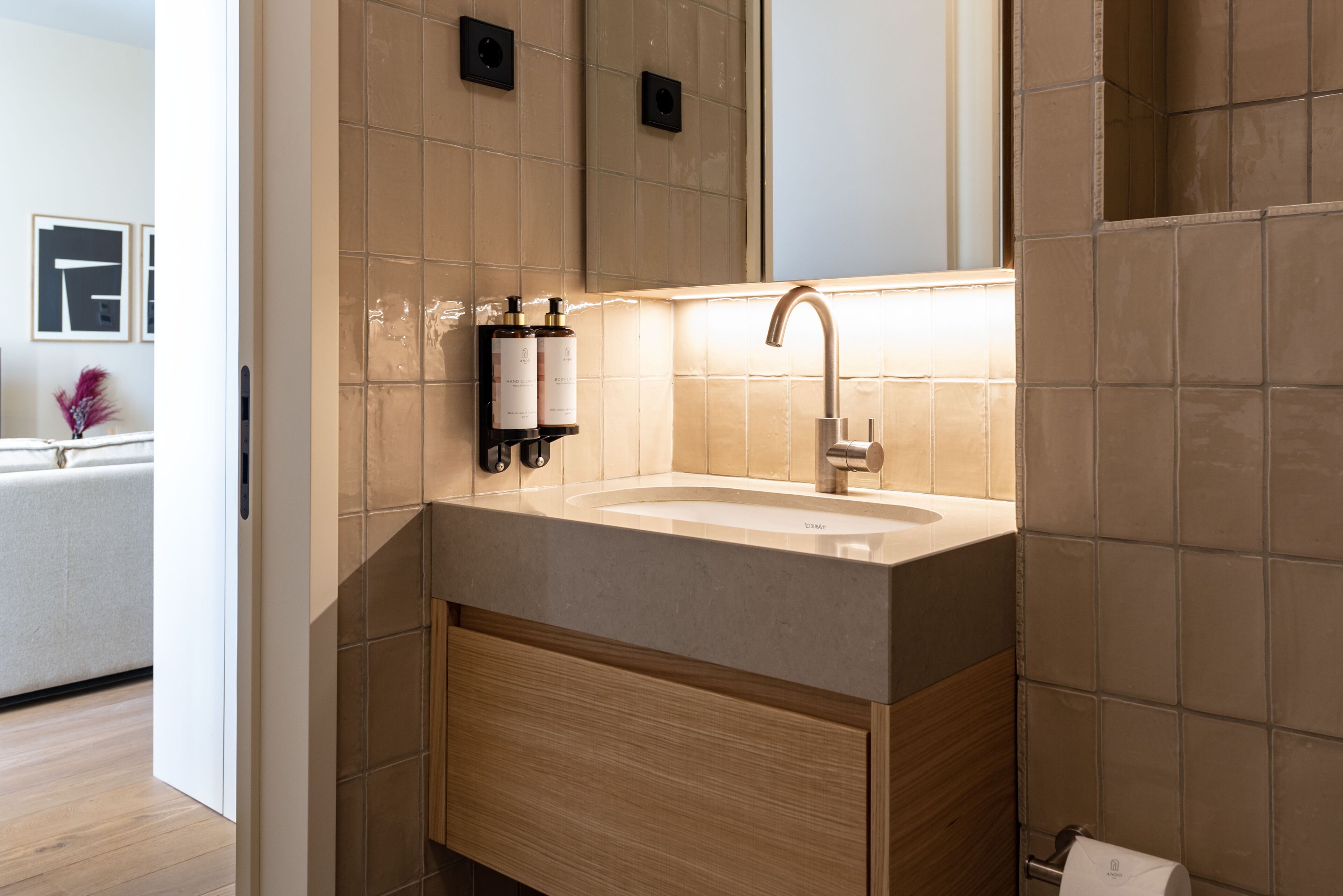 Une salle de bain moderne avec un lavabo beige, un meuble en bois et un miroir au-dessus.