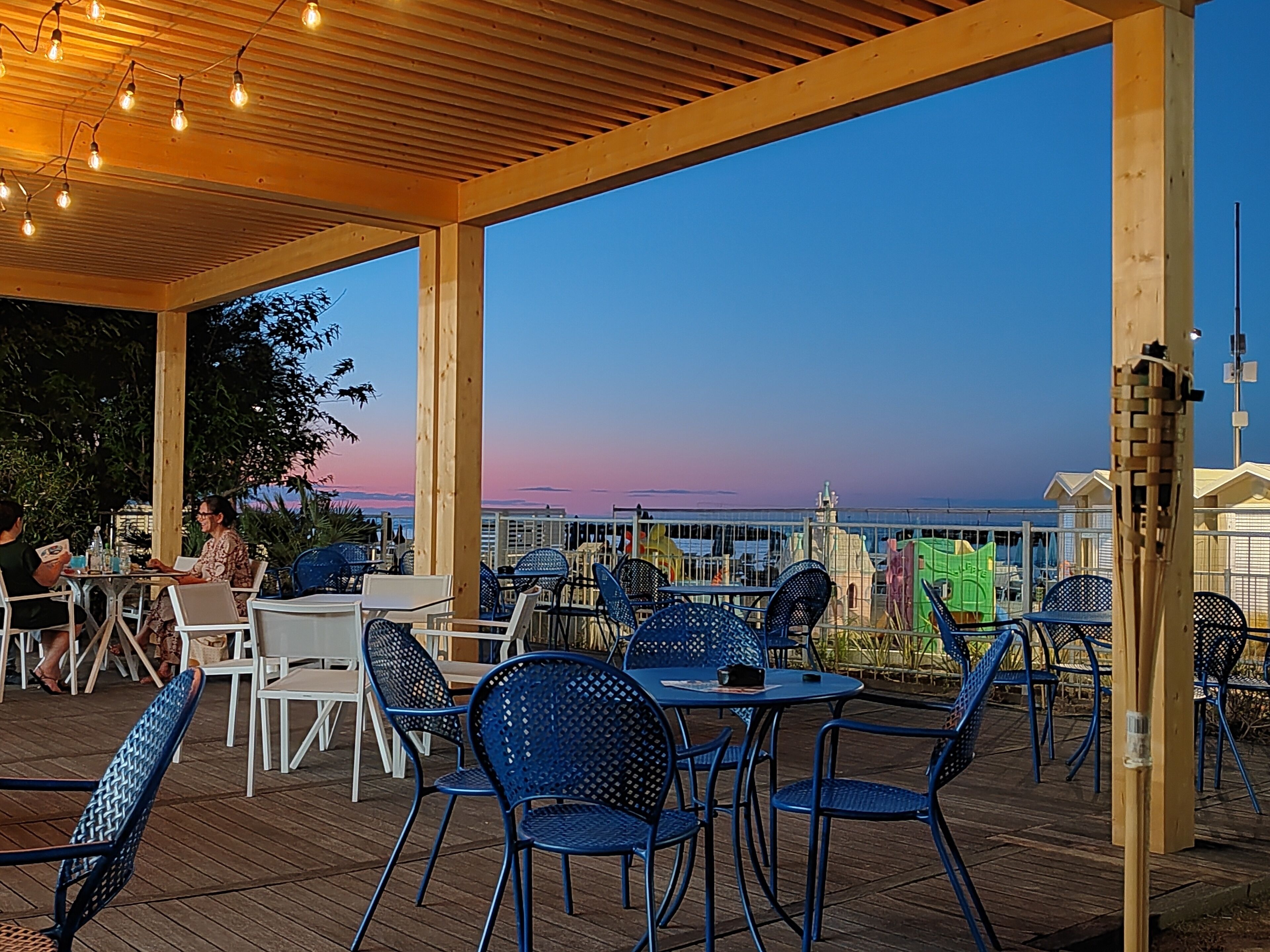 An outdoor seating area with tables and chairs, overlooking a scenic view.