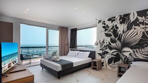 Ein modernes Hotelzimmer mit einem großen Bett, einem Schreibtisch und Blick aufs Meer.