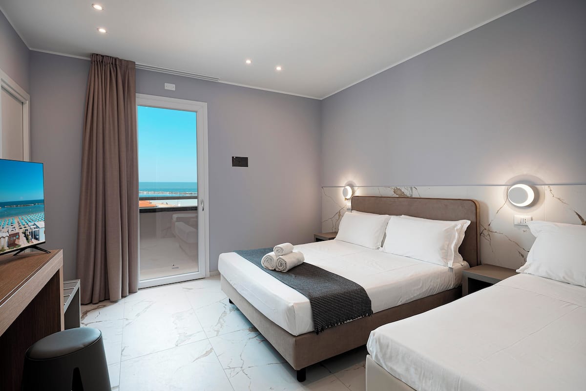 Una habitación de hotel con una cama, un escritorio y un televisor.