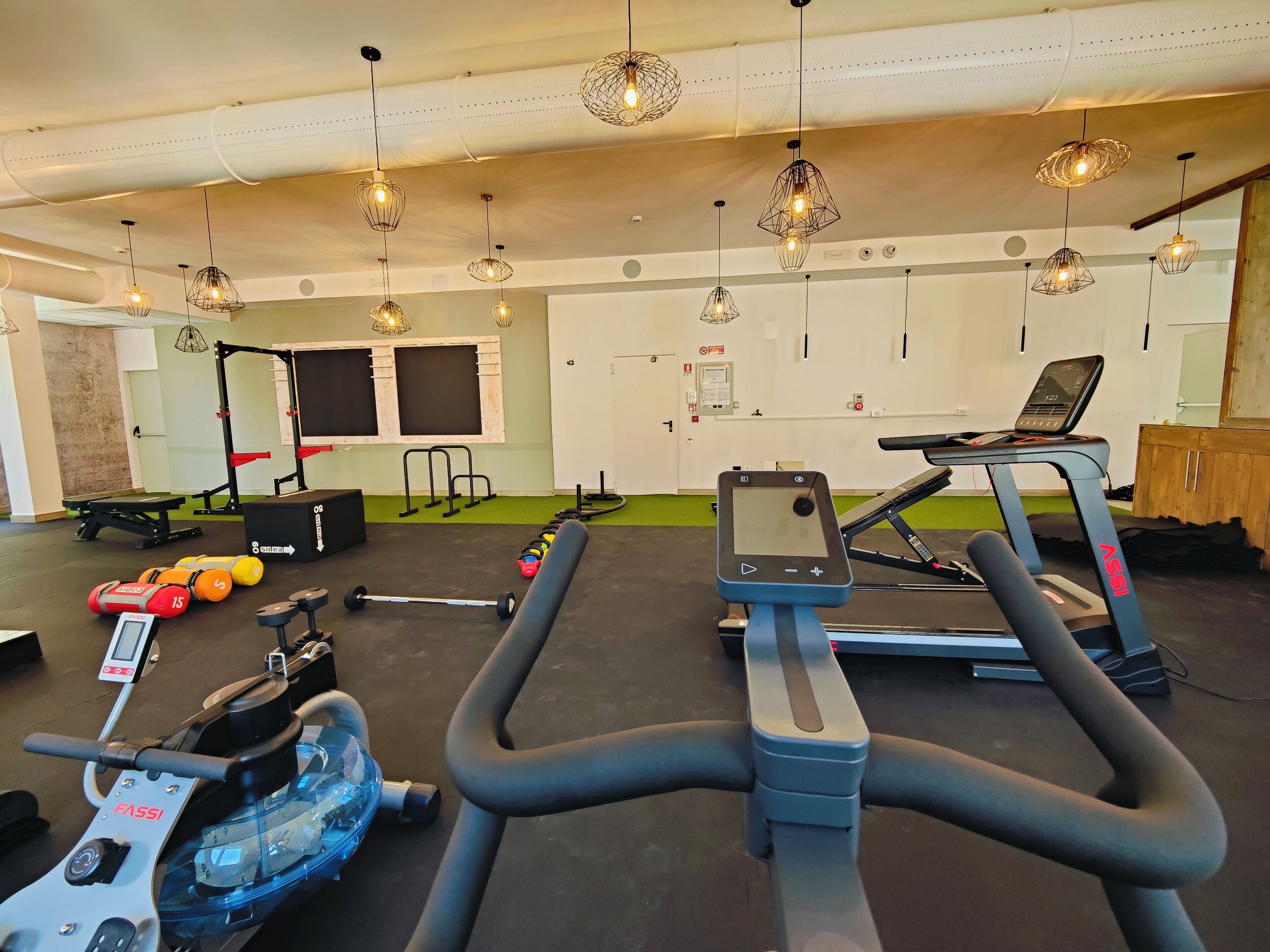 Una palestra con tapis roulant, cyclette e attrezzi per sollevamento pesi.