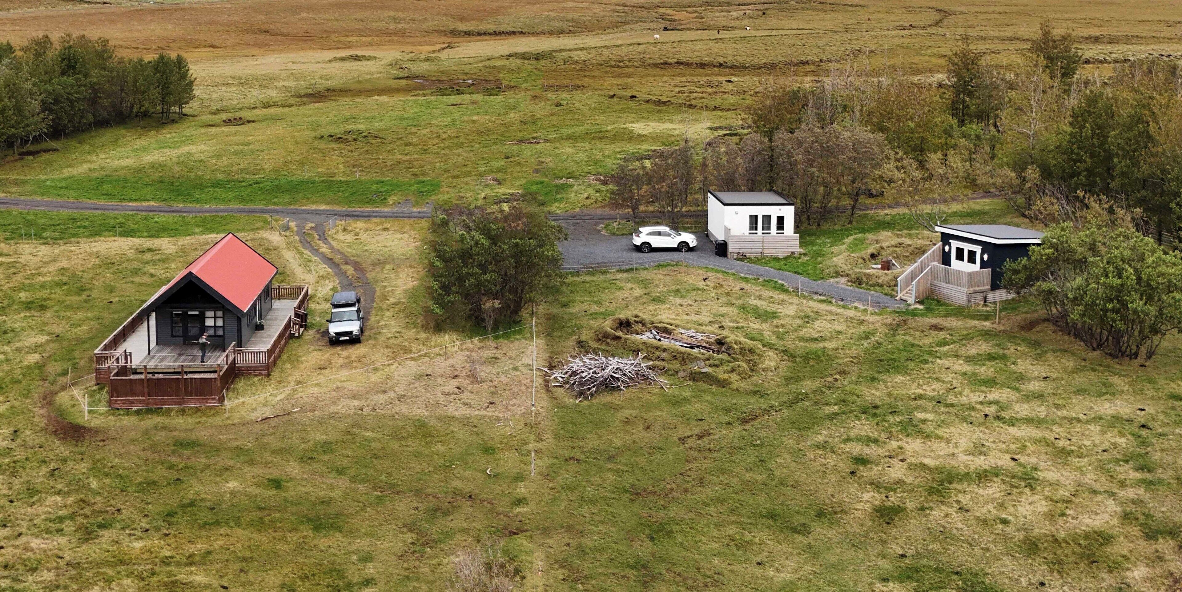 A rural property with a main house, a smaller white building, and a garage.