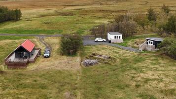 A rural property with a main house, a smaller white building, and a garage.