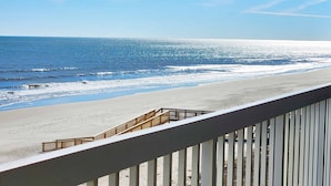 A beach view from a balcony with a railing, ocean, and clear sky. - Cambridge 404 - 3 Bedrooms - 2 Are Oceanfront - Amazing! (Pawleys Island)